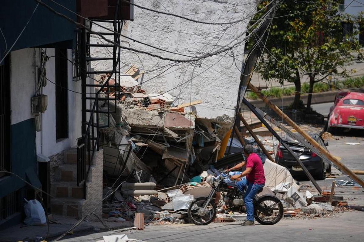 Un hombre observa los escombros de un edificio colapsado en Pereira, Colombia.