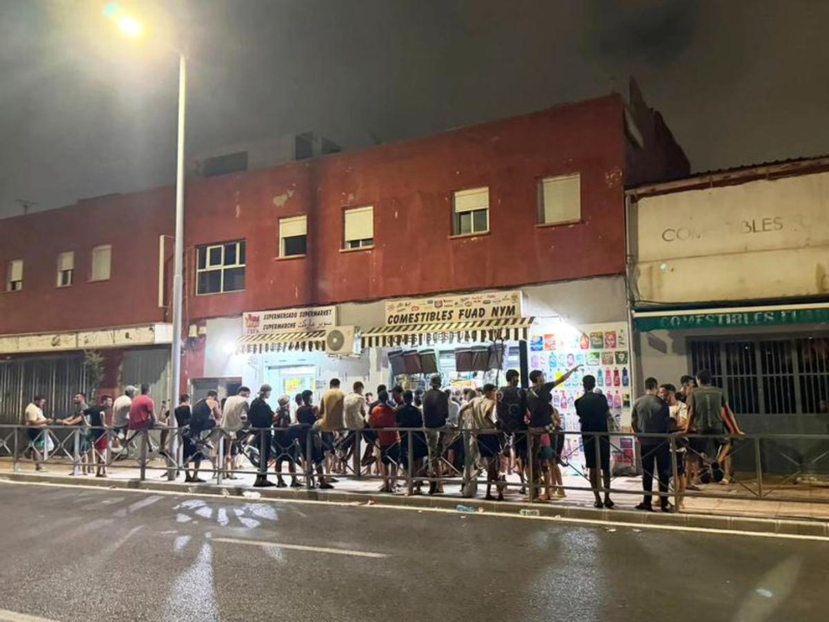migrantes irregulares reuniéndose afuera de una tienda de conveniencia, en el enclave español de Ceuta, en el norte de África.