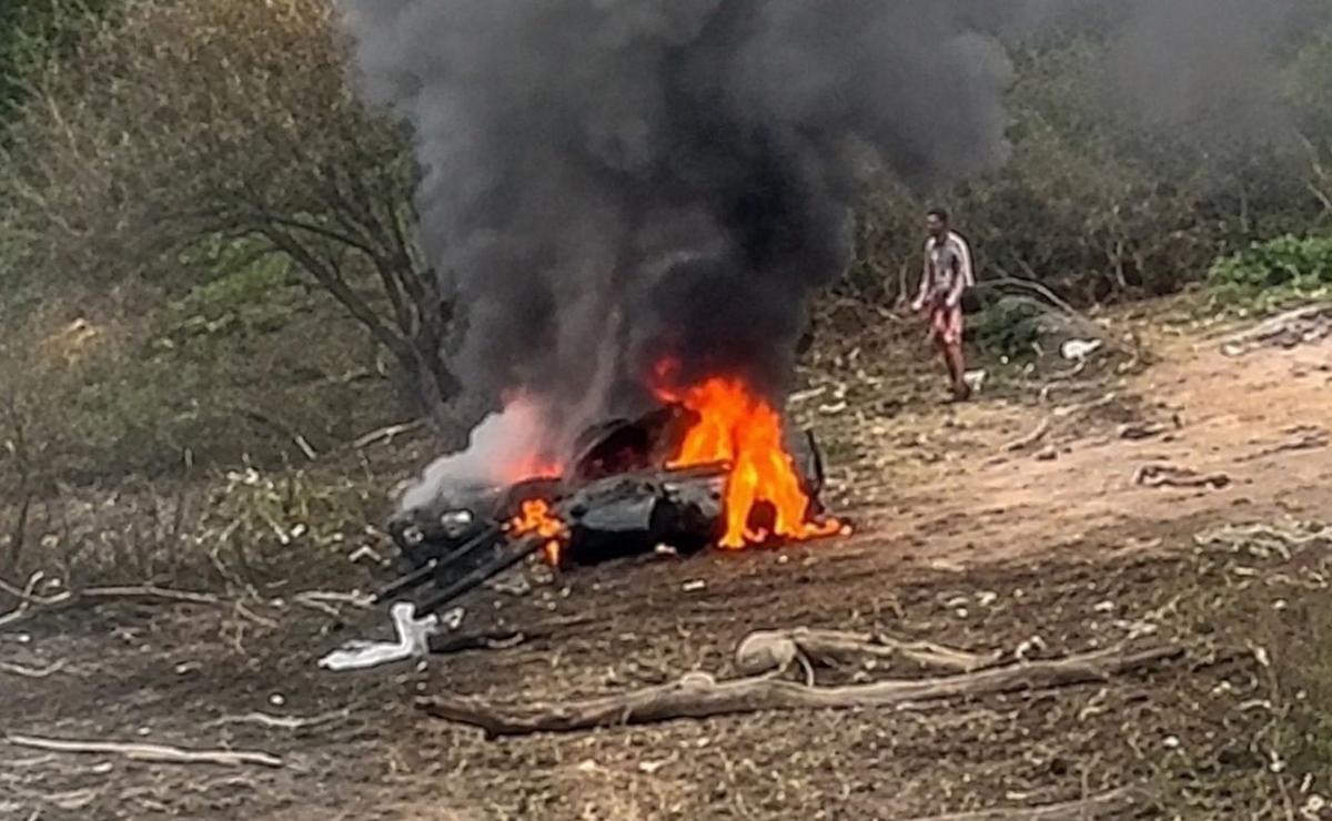El auto incendiado, con las dos personas adentro.