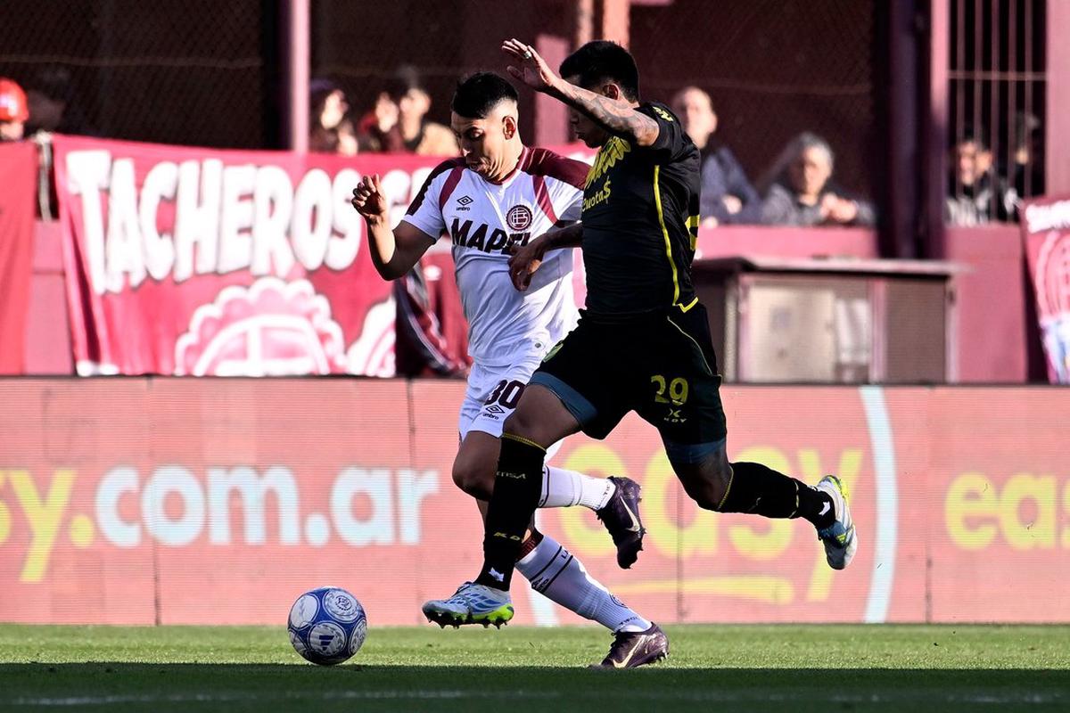 Agustín Cardozo encara ante la marca del defensor Damián Fernández en el triunfo del local.