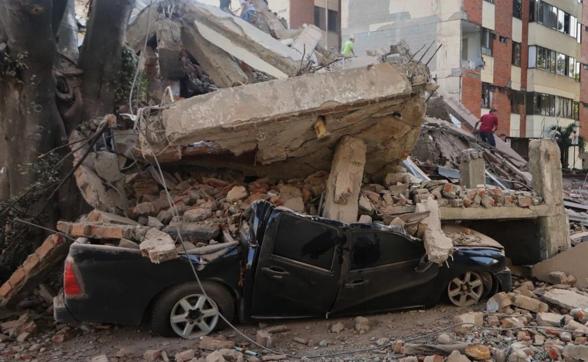 Residentes y equipos de rescate buscan entre los escombros tras un terremoto.