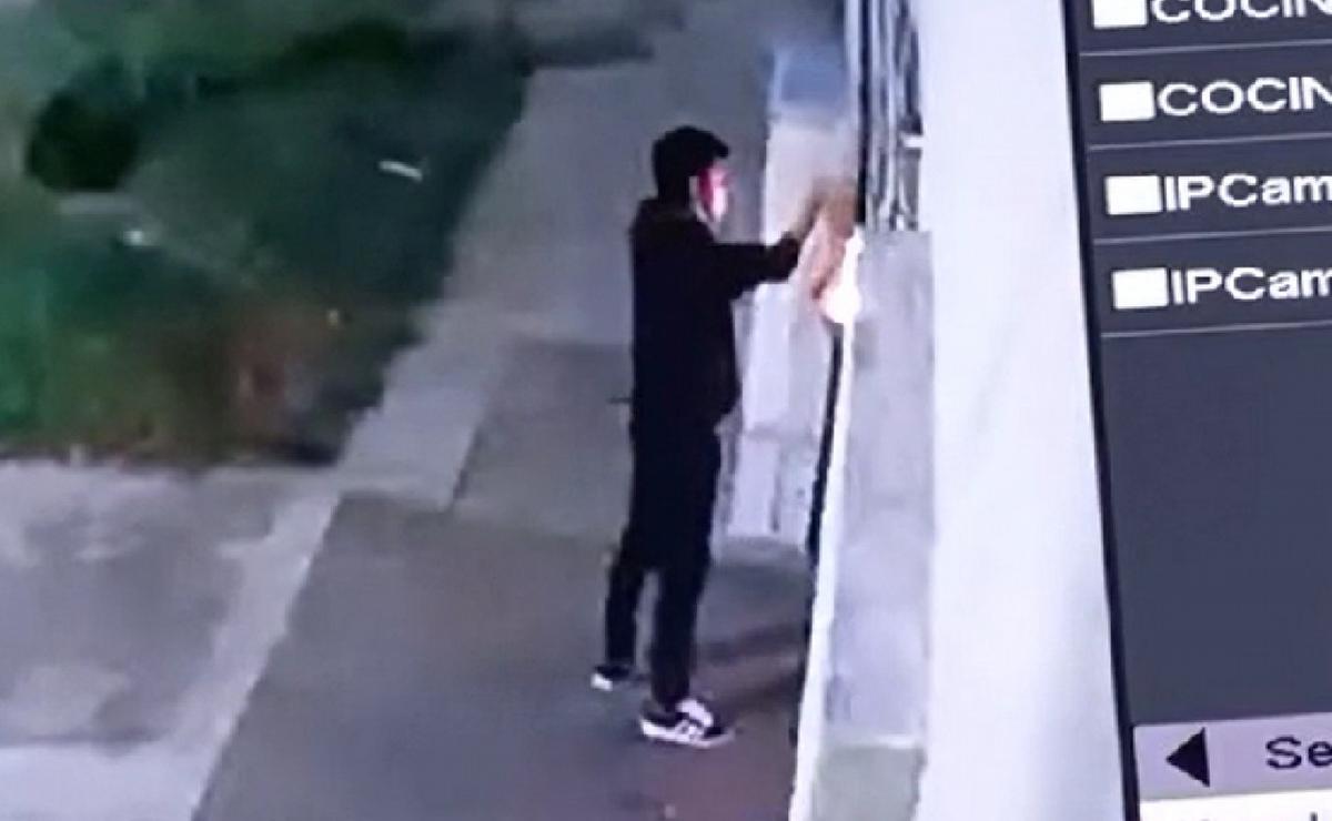 FOTO: El momento en que el joven tiraba basura en una casa para prenderla fuego. (Captura)