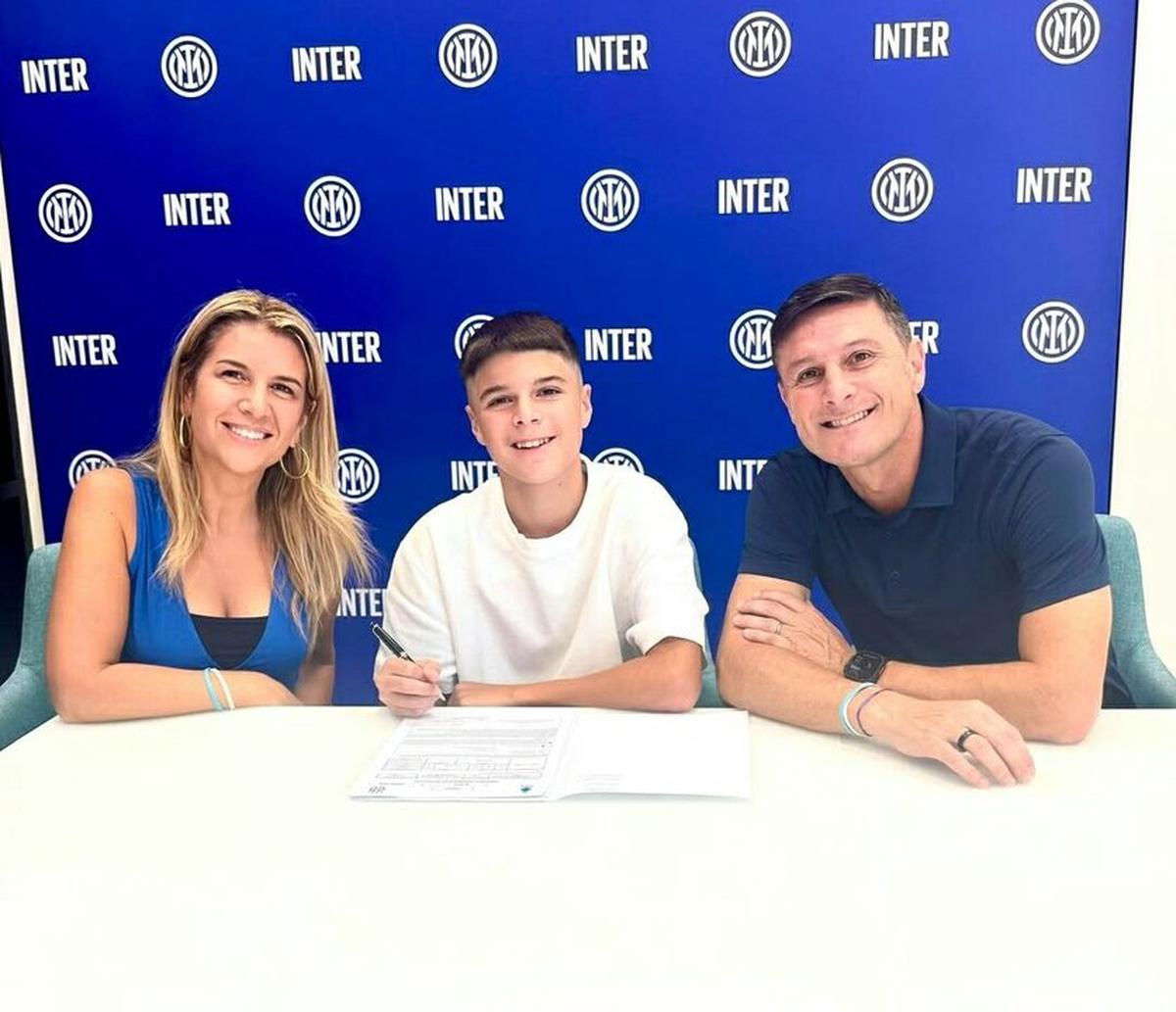 Tomás Zanetti acompañado de sus padres, firmando su contrato.