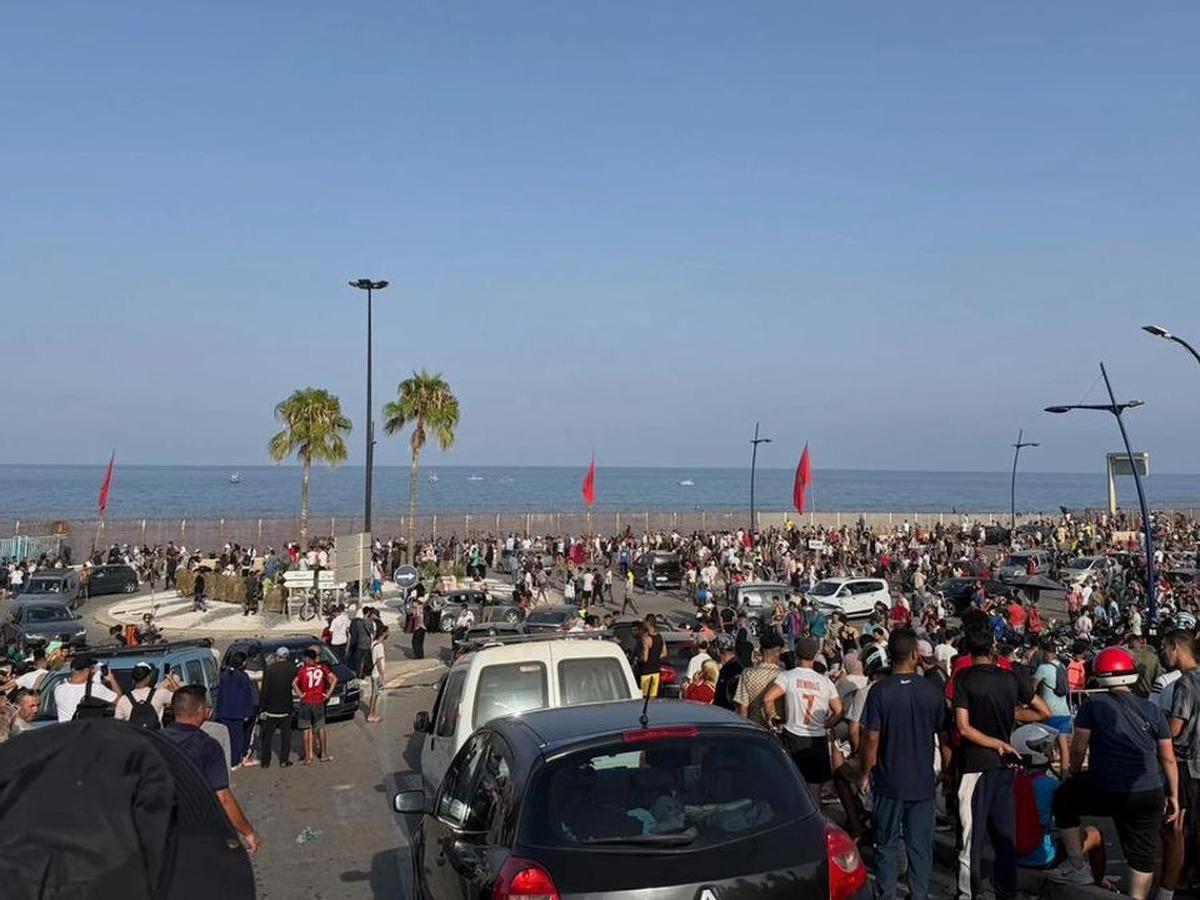 Personas se reúnen en el lado marroquí de la frontera con Ceuta, en el norte de África, preparándose para cruzar.