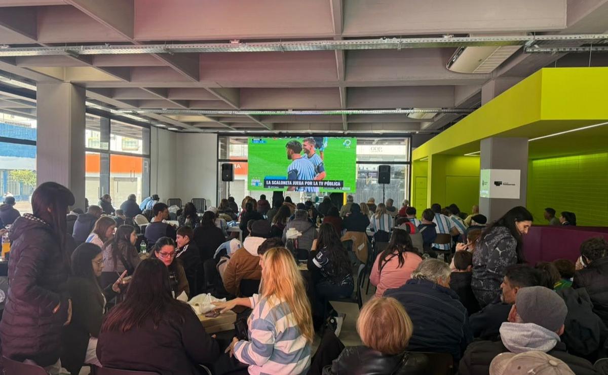 Hinchas rosarinos reunidos viendo el partido en pantalla gigante.