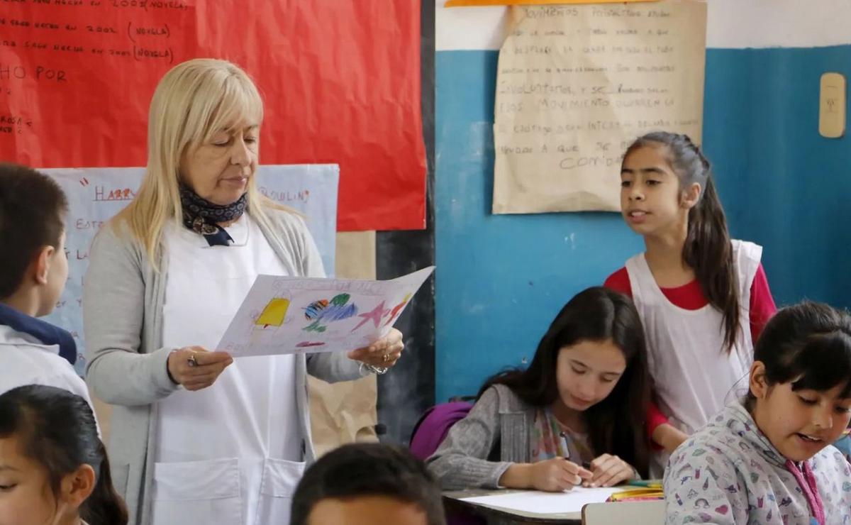 Una docente en el aula junto a sus alumnos.