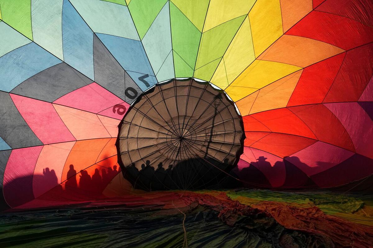 Globos de tres países tiñen de colores el amanecer en la mitad del mundo