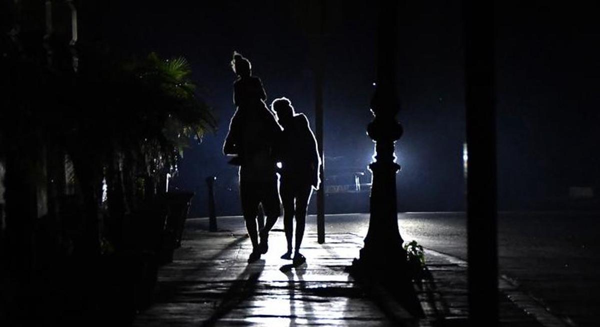Una familia camina por La Habana, a oscuras.