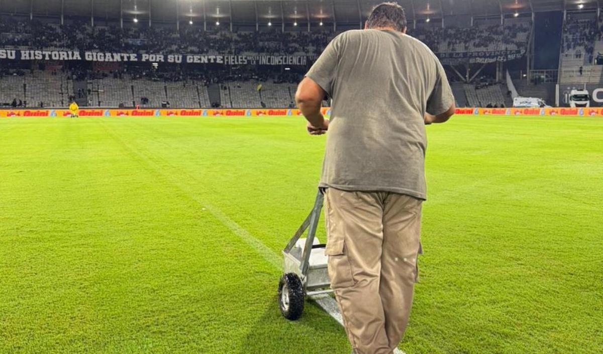 Pintan las líneas del campo de juego, que se habían borrado por el agua.