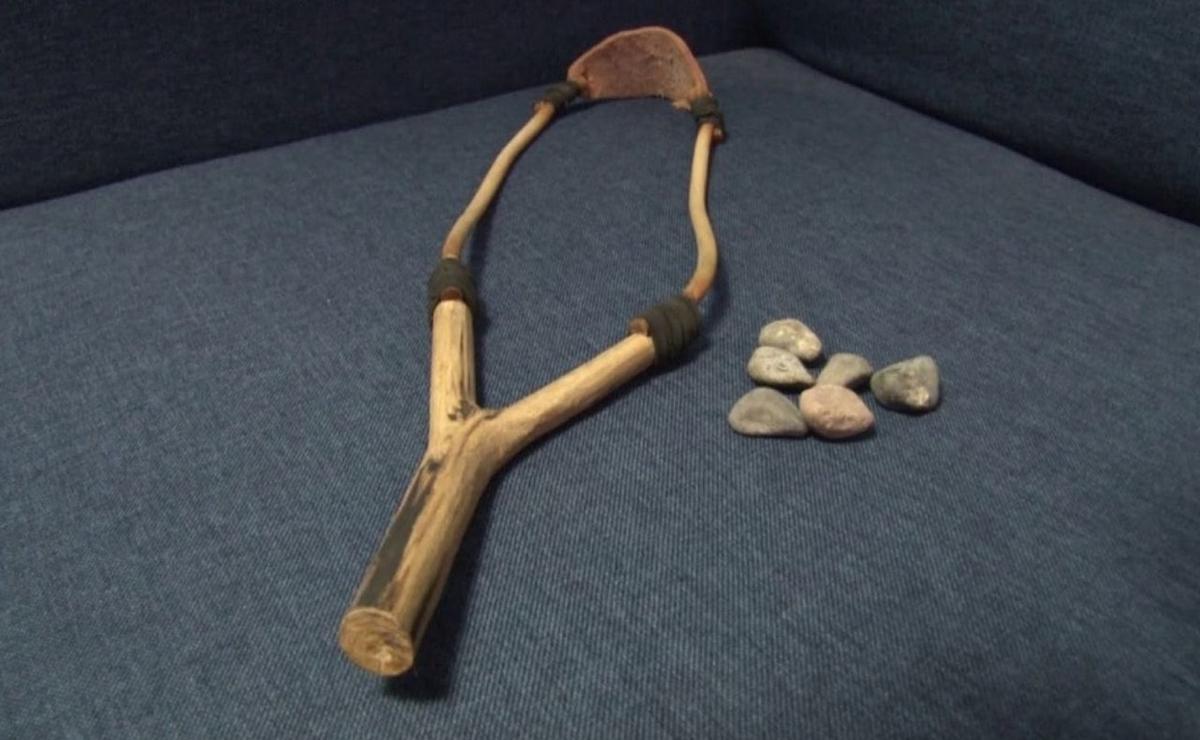 Una gomera y objetos para arrojar con ella.