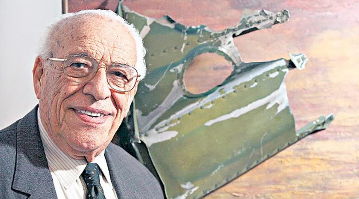 Roberto Servente posa junto a una pieza del fuselaje recuperada del mar, que conservó