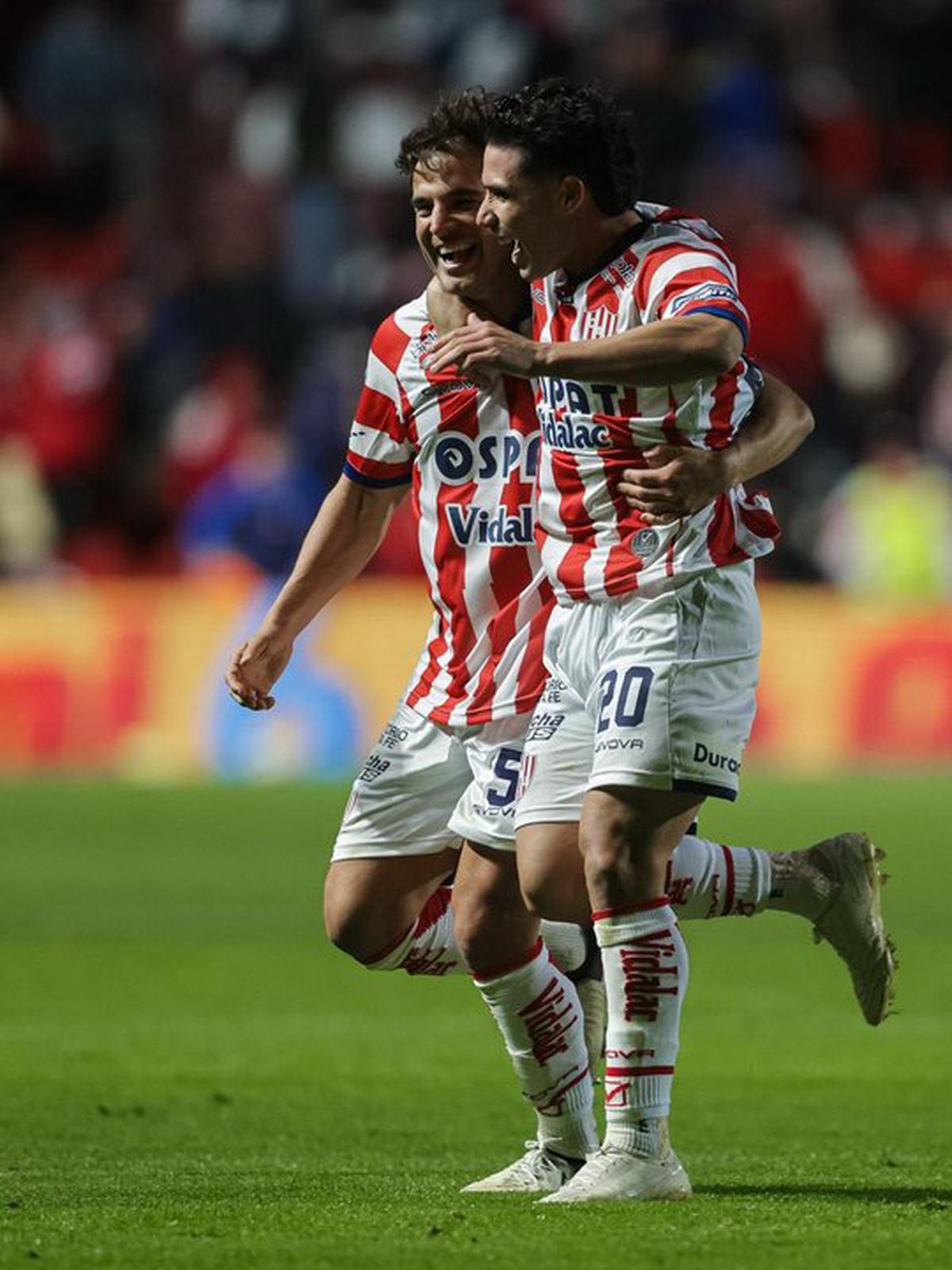 Lucas Menossi (izquierda) festeja el primer gol de la noche junto a Julián Palacios.