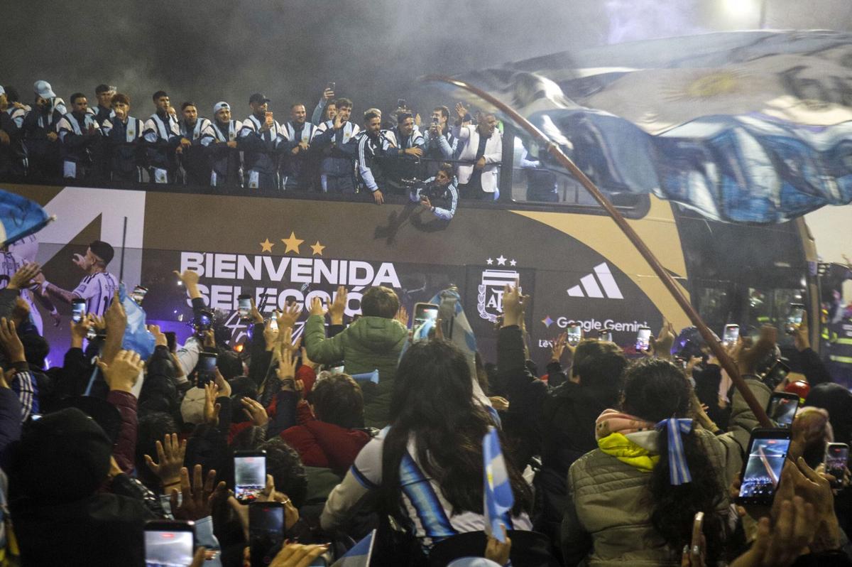 Los jugadores saludan a los hinchas desde el colectivo descapotable que los lleva al predio de AFA.